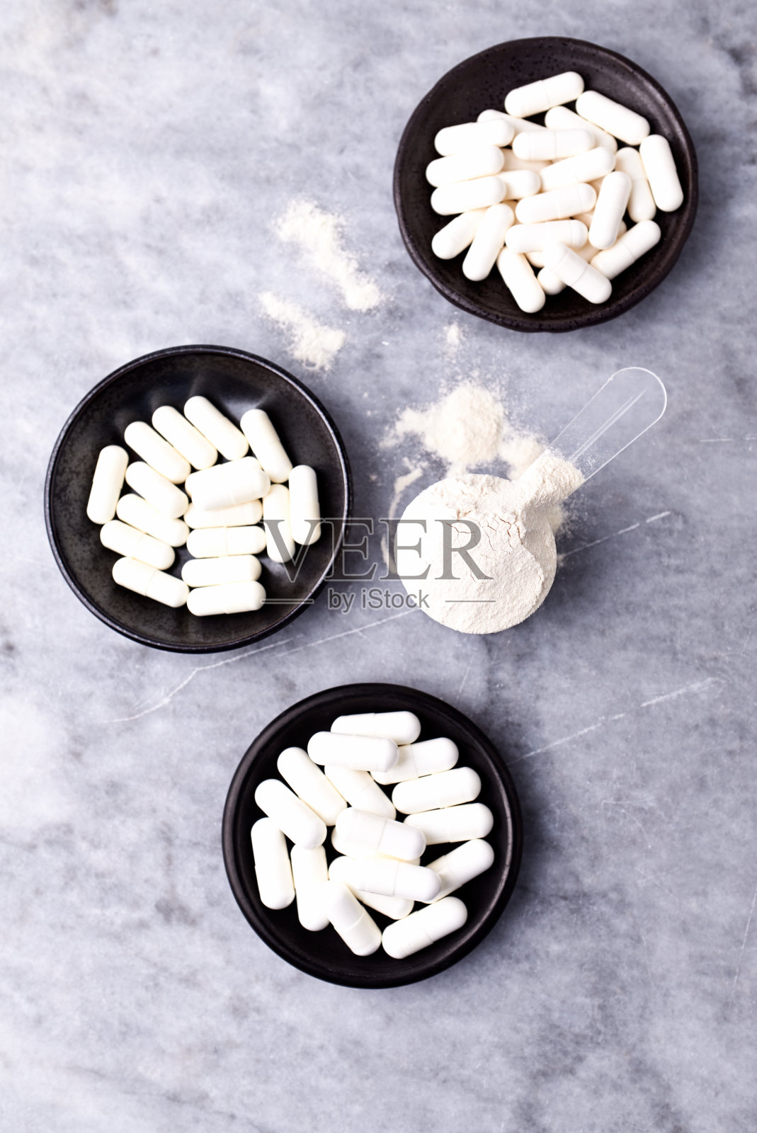 乳清蛋白,水解膠原I型,l -脯氨酸和l -賴氨酸膠囊勺。補(bǔ)充膠原蛋白的生產(chǎn)。明亮的石頭背景。直接上圖。副本的空間。
